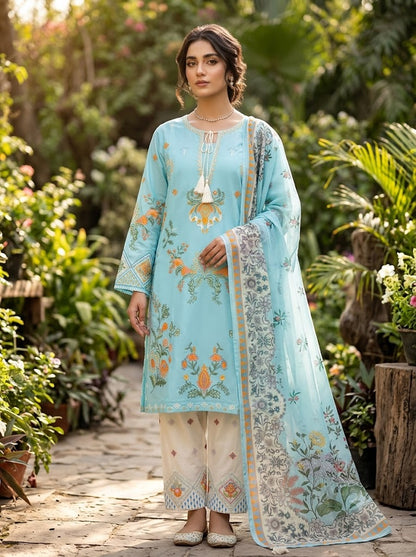 Woman in a light blue embroidered outfit standing in a garden